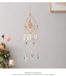 Detail of crystal suncatcher with golden geometric frame and teardrop prisms