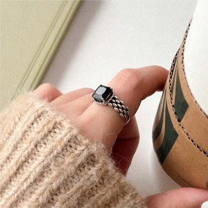 Detailed view of vintage silver ring with black square zircon and woven texture band