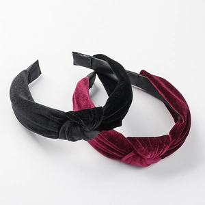 Detail of knotted velvet headbands in black and wine red colors for women