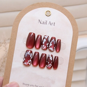 Detail of 10-piece cat eye press-on nails with butterfly motifs and red floral patterns