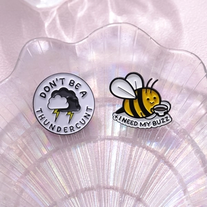 Funny enamel pin set featuring a thundercloud and coffee bee on an iridescent tray