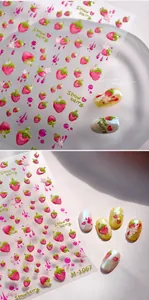 Macro view of 3D embossed strawberry nail decals showing detailed glossy textures