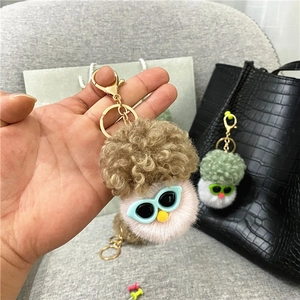 Detailed macro shot of a plush vegetable doll keychain with curly hair and blue sunglasses
