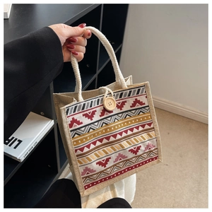 Détail d'un sac en lin à motifs ethniques avec bouton en bois et anse en corde de coton