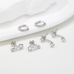 Macro detail of three silver earrings featuring pavé cubic zirconia on stone tray