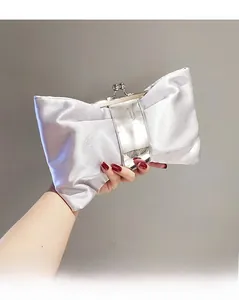 Detailansicht einer silbernen Satin-Abendtasche mit einem eleganten Schleifen-Design