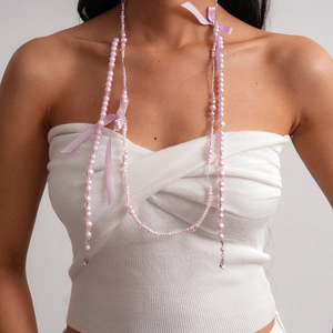 Collier en perles roses avec nœuds lavande et glands en cristal sur un mannequin