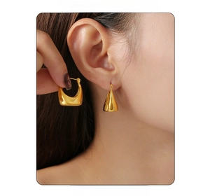 Macro shot of 18K gold plated PVD geometric hoop earrings worn by a model