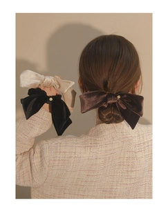 Elegant velvet bow hair scrunchies in beige, black, and brown with gold ring detail