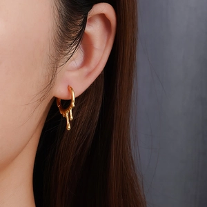 Irregular liquid gold lava earrings in stainless steel on model with side view