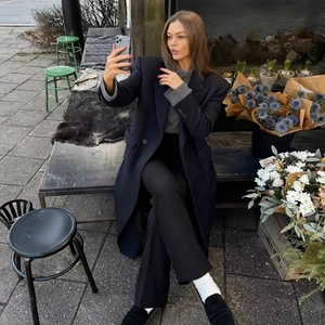 Outdoor shot of a women's dark striped cashmere coat with waist-slimming silhouette