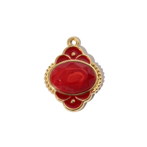Detailed macro view of vintage gold pendant with red enamel stone and ornate beadwork edges