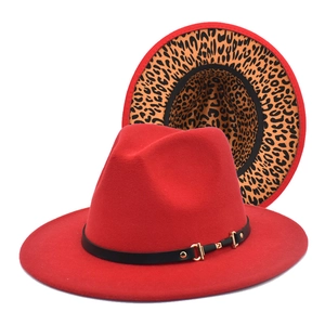 Detail of red fedora hat featuring leopard print brim underside and gold buckle strap