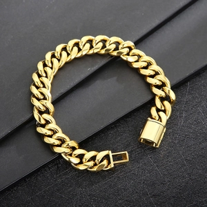 Macro detail of 12mm golden Cuban link bracelet with open square clasp on black texture