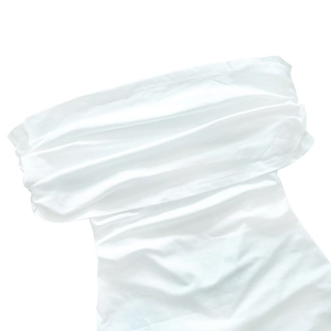 Detailed close-up of white off-shoulder dress featuring ruched design and layered fabric texture