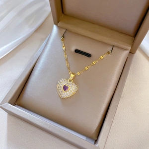 Luxurious gold stainless steel necklace with purple heart gemstone in a beige jewelry box