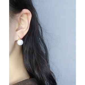 Elegant S925 sterling silver hoop earrings with round white pearls on a model