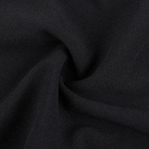 Macro shot of black chiffon fabric showing detailed grainy texture and elegant draping folds