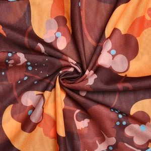 Vue macro du tissu en maille avec motifs floraux vintage aux tons orange brun et rose