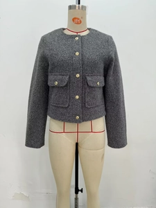 Detail of grey tweed jacket showing gold embossed buttons and textured woven fabric