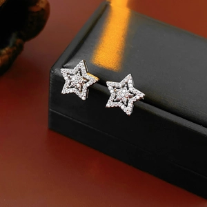 Close-up of silver star stud earrings with pavé cubic zirconia on a black jewelry box