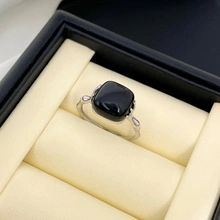Macro di un anello in argento S925 con gemma quadrata nera in una scatola regalo