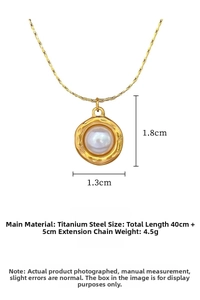 Detail of gold titanium steel necklace with a white pearl in a hammered oval frame