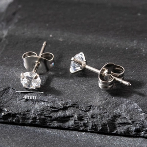 Detailed 4mm classic four-prong round zircon stud earring shown on natural slate