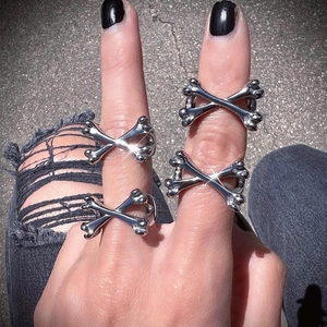 Dettaglio di anelli a croce d'argento con ossa indossati in stile punk di strada