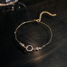 Close-up of golden chain bracelet with crystal ring and adjustable lobster clasp closure