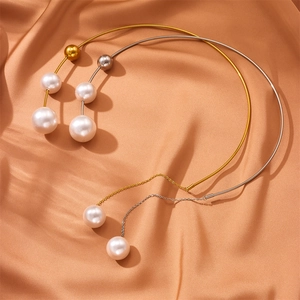 Minimalist stainless steel pearl fringe necklace in gold and silver on orange silk fabric