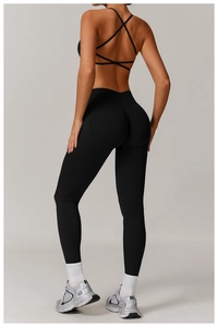 Rear view detail of black high-waisted seamless yoga leggings and strappy sports bra set