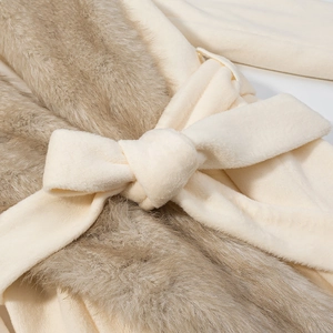 Détail de la ceinture nouée sur un manteau beige en peluche et fausse fourrure