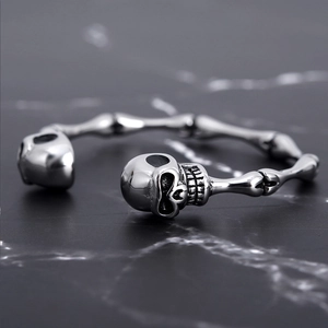 Skeleton bone bangle in polished silver steel featuring detailed skull heads and bone joints
