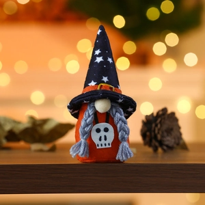 Halloween gnome doll with black star wizard hat and white skull on orange fabric body
