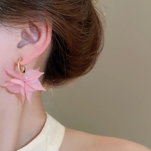Detail of pink acrylic petal earrings with gold hooks on a female model
