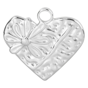 Vue macro du pendentif coeur argenté avec motifs floraux et texture de métal martelé