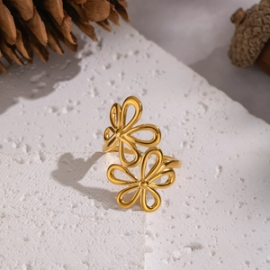 Elegant gold double flower open ring with hollowed petals on a white stone background