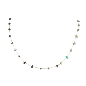 Detailed shot of golden necklace with colorful irregular natural stone beads and charms