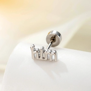 Minimalist silver alphabet stud earring featuring him letter design on a soft beige background