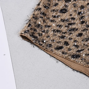 Macro shot of sequins and leopard print texture on high-waisted shorts with brown piping