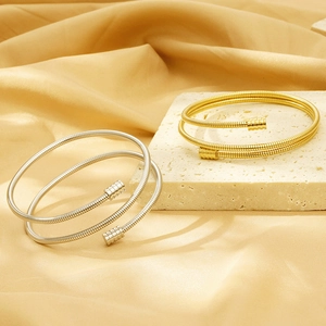 Detailed view of layered spiral 18k gold and silver flexible cable spring bangles