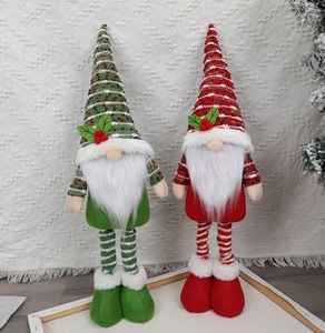 Nahaufnahme von roten und grünen Strick-Weihnachtswichteln mit langen Beinen