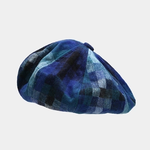 Close-up of blue and black plaid pattern texture on the wool blend beret hat