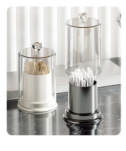 Close-up of clear acrylic storage jars with crystal handles for cotton swabs and toothpicks