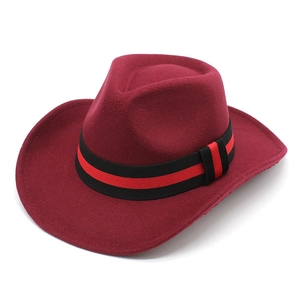 Detail of burgundy wool western cowboy hat with striped band and curved brim texture