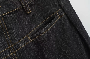 Dettagli del tessuto denim nero con tasche rinforzate e doppia cucitura a contrasto gialla