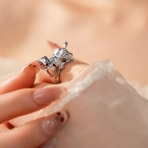 Macro view of silver puppy ring with sparkling stones and delicate pearl collar