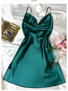 Detail of silk satin nightdress with thin straps and V-neckline in deep green fabric