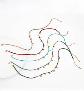 Detailed close-up of colorful natural stone beaded necklaces with gold circular pendants
